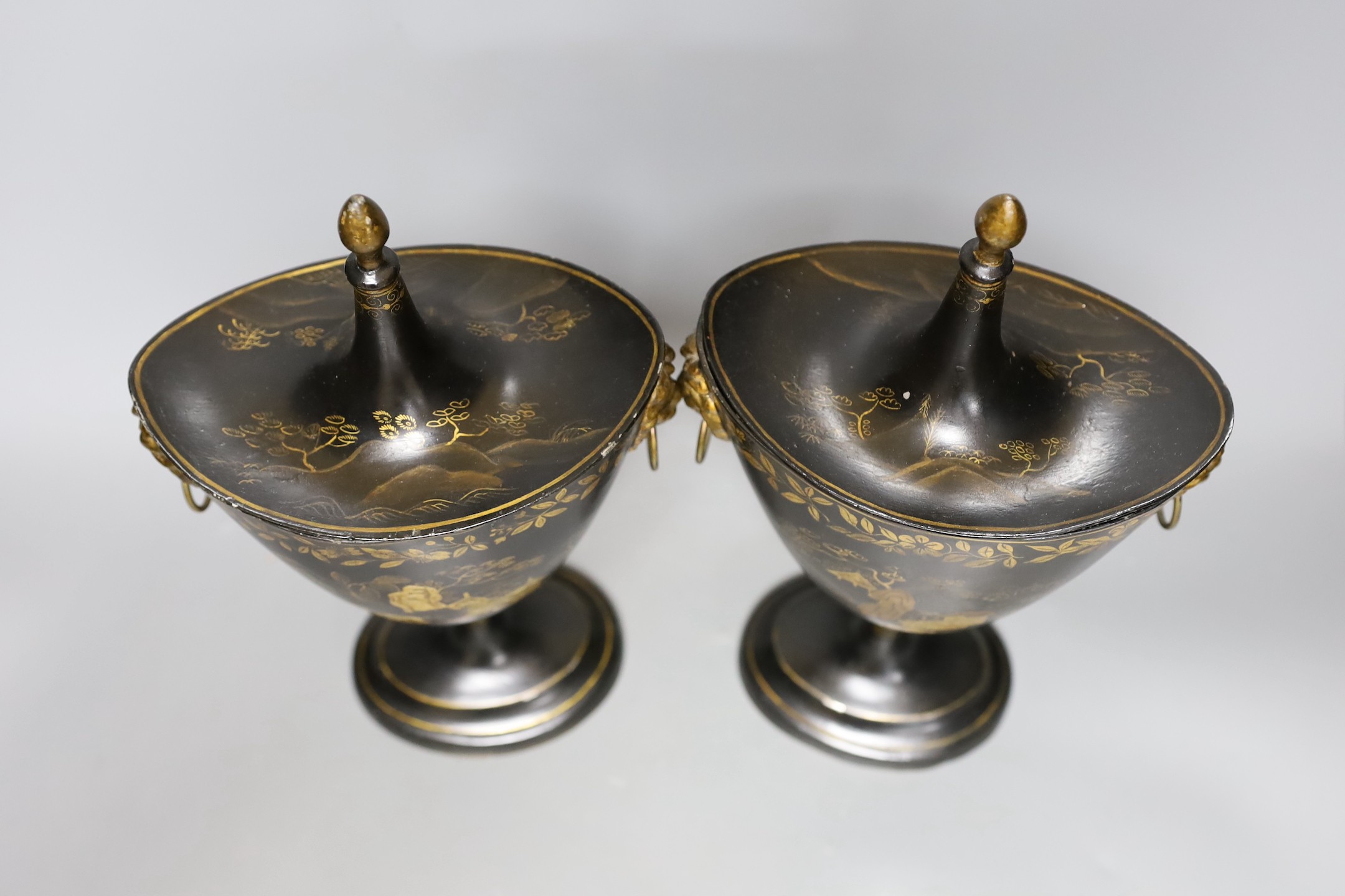 A pair of Japanned toleware urns and covers, 33cm tall